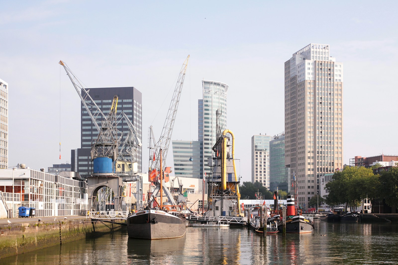 a harbor filled with lots of boats next to tall buildings