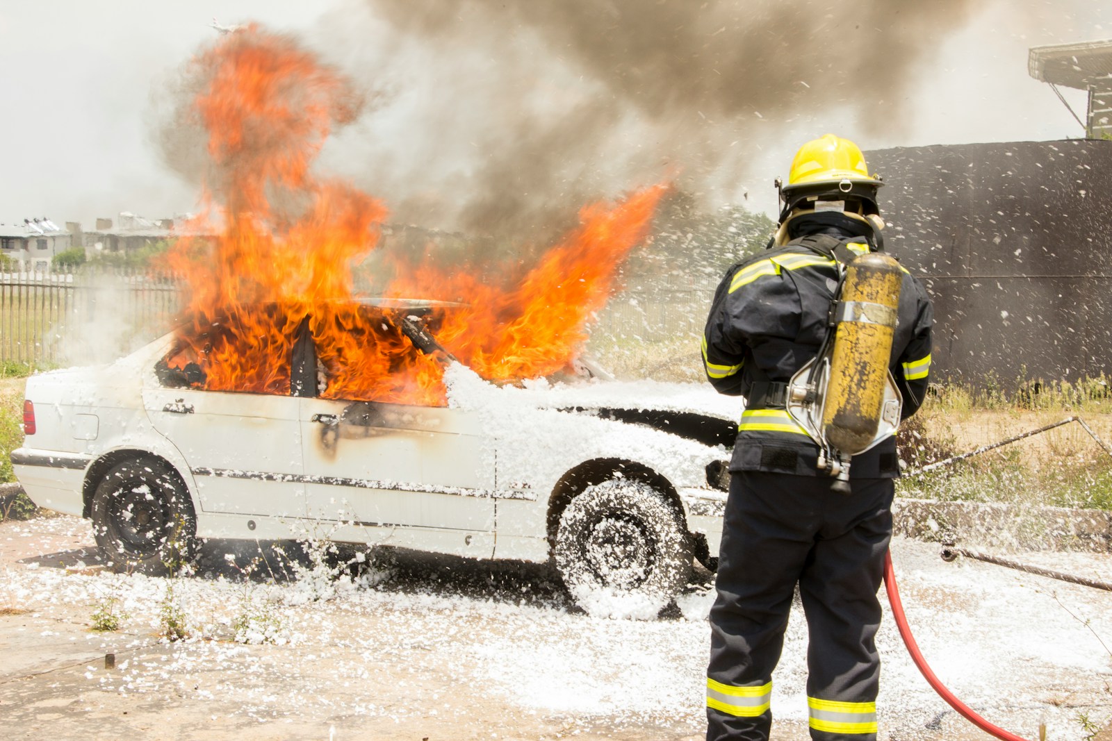 firefighter fighting burning car