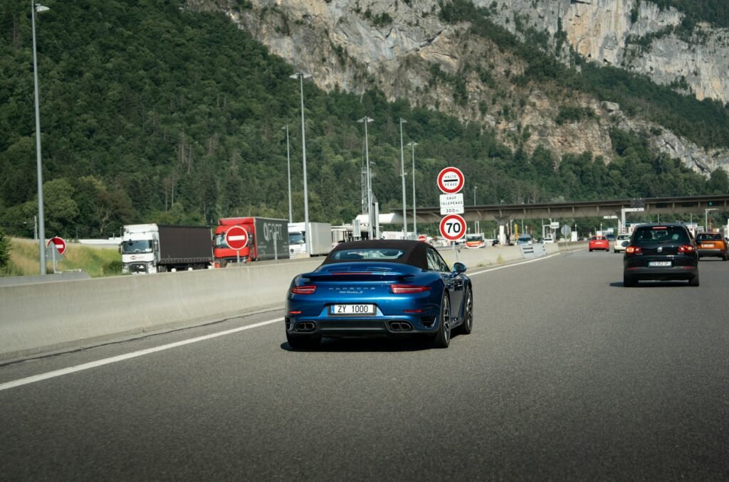 A blue sports car on a highway.