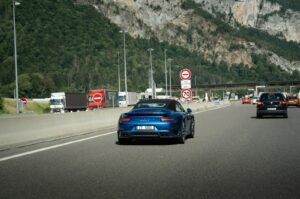 A blue sports car on a highway.