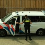 a police officer standing next to a van