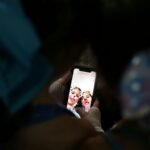 person holding white card with man in black suit jacket